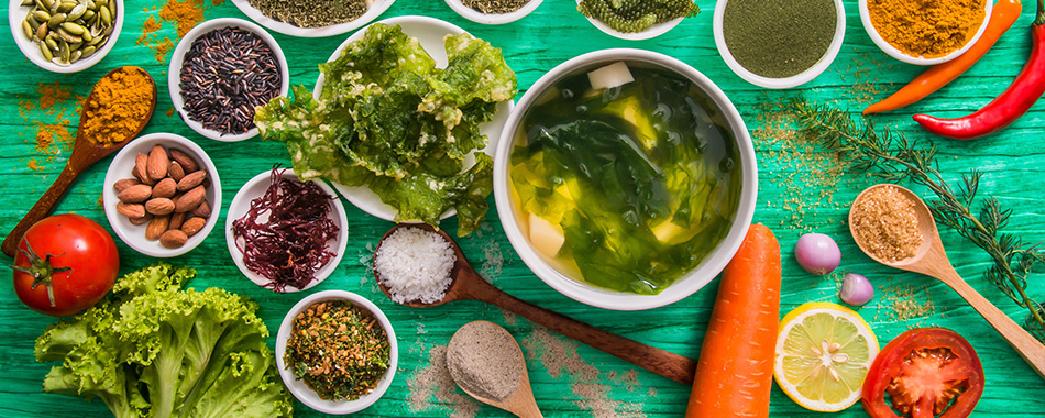 An image with multiple bowls of letuce and vegetables on a wooden table